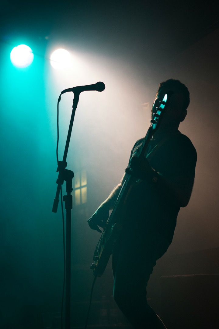 Musicien sur scène devant un pied de micro pendant la balance son d’un concert