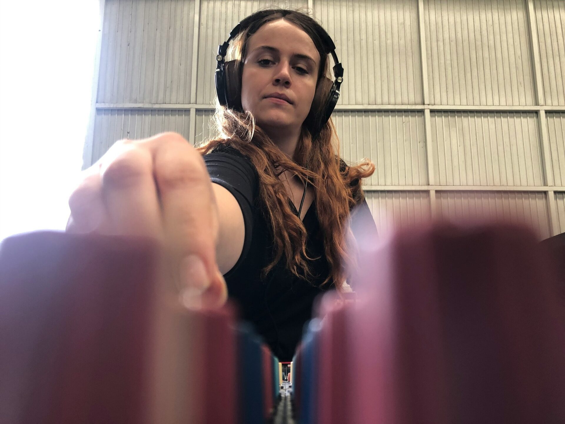 Éviter le larsen en concert : technicienne son au casque réglant une console de mixage
